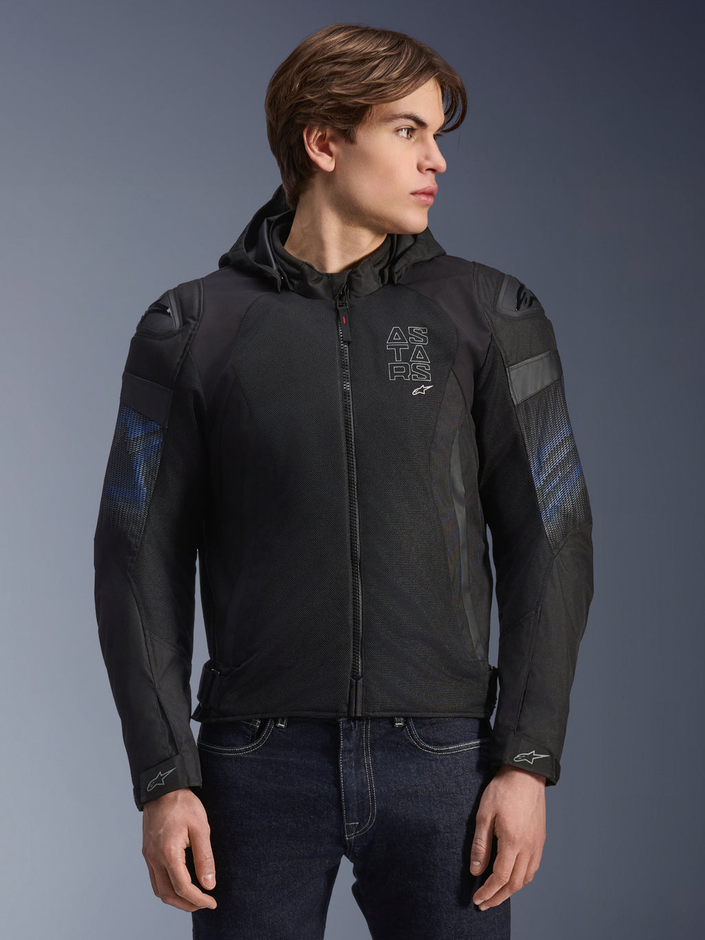 Casaco Alpinestars Zaca Air Venom WP, preto e azul elétrico, casaco de motociclismo têxtil com capuz removível e painéis em malha 3D para ventilação, com deslizadores de ombro DFS Lite e logótipo ASTARS no peito, vestido por um modelo masculino, equipamento de condução urbana de inspiração desportiva