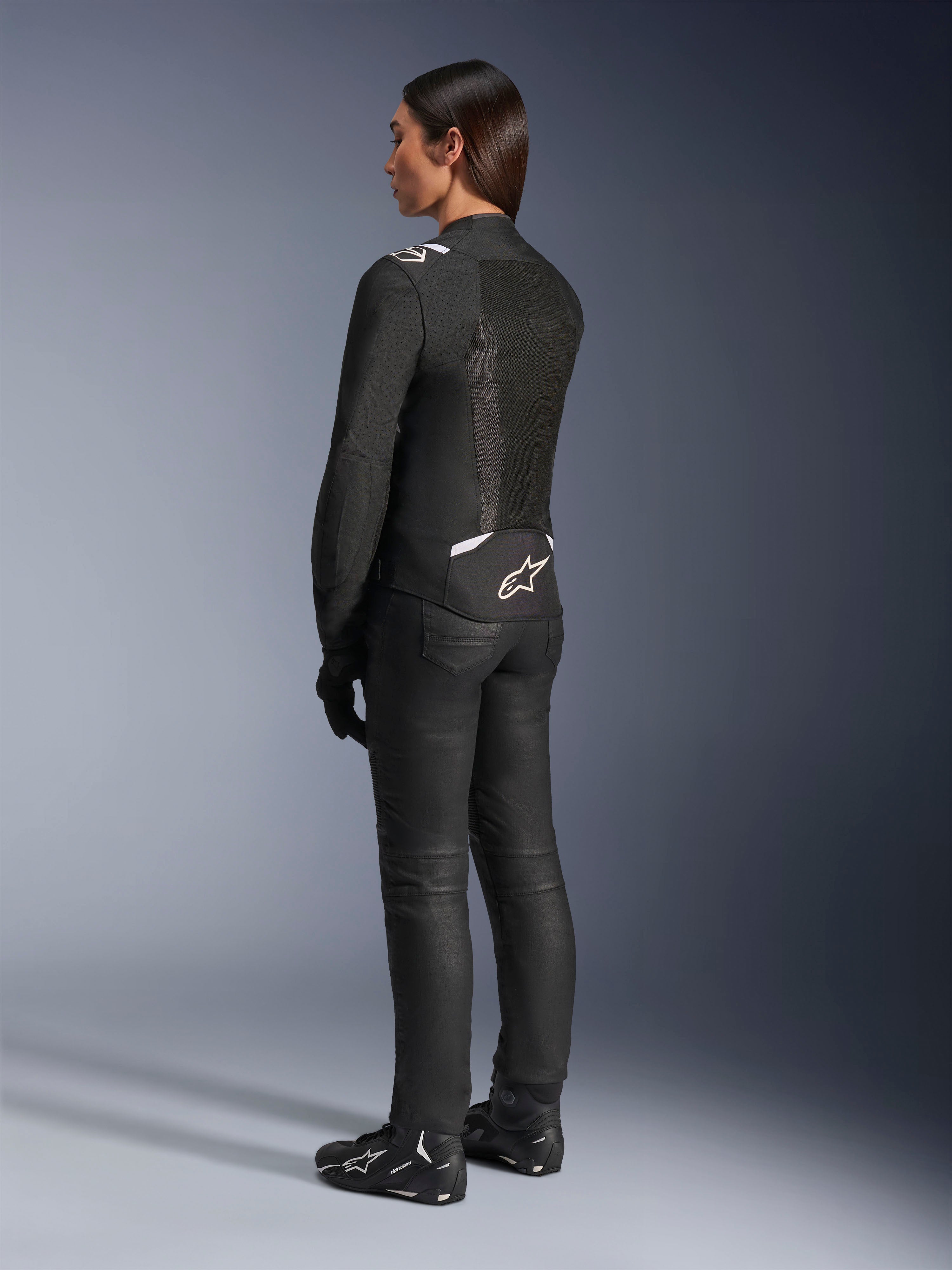 Alpinestars Stella T-Sps Air V2 Jacket, Black and White, back view showing mesh panels and logo on the lower back, paired with black riding pants and motorcycle shoes, sporty textile road gear for women