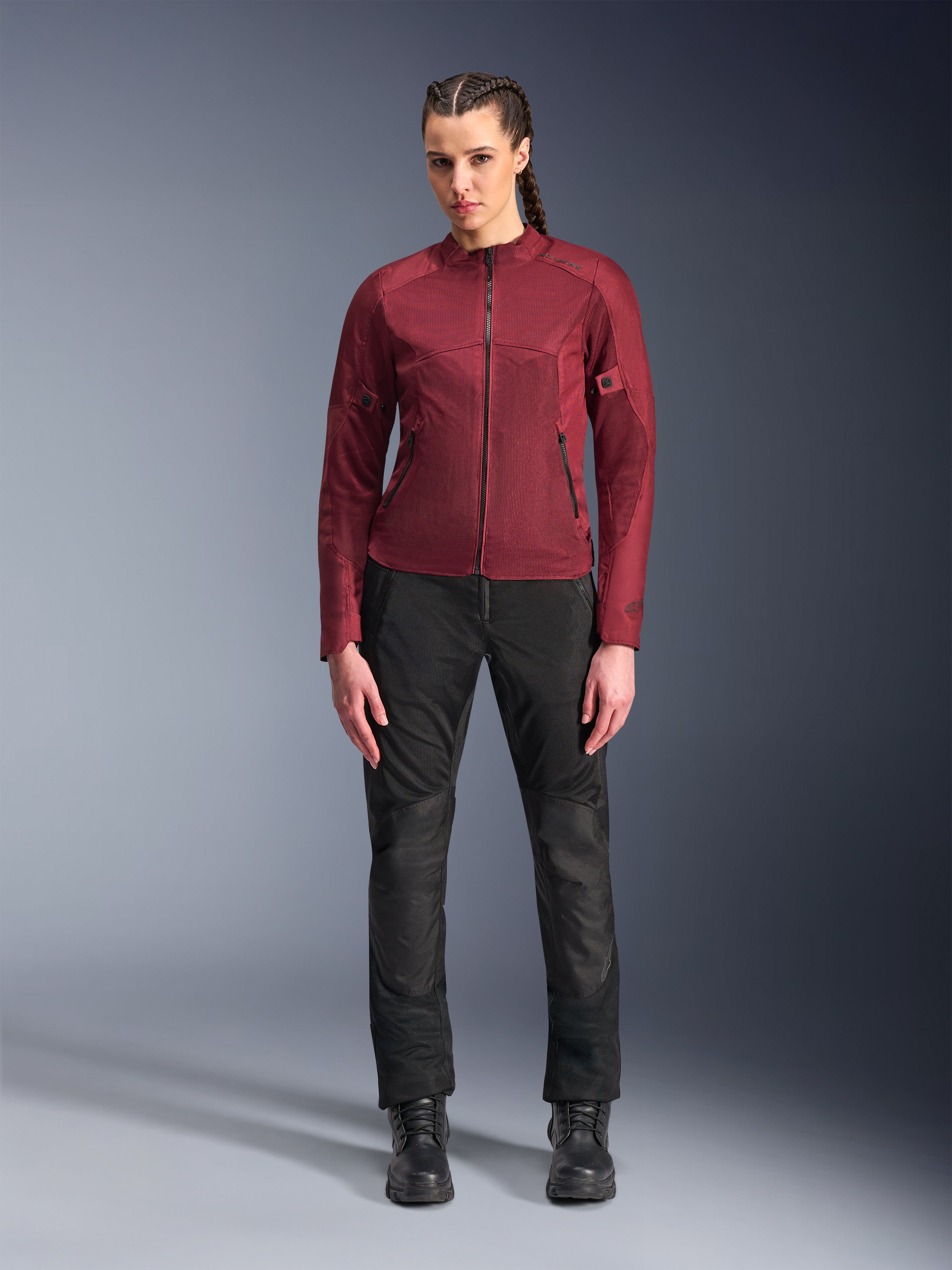 Alpinestars Stella C-1 Air Pants, calças de motociclismo urbanas para mulher, pretas, com construção em tecido e malha, combinadas com um casaco Stella C-1 Air bordeaux e botas de pele pretas, estilo de condução urbana clean e moderno