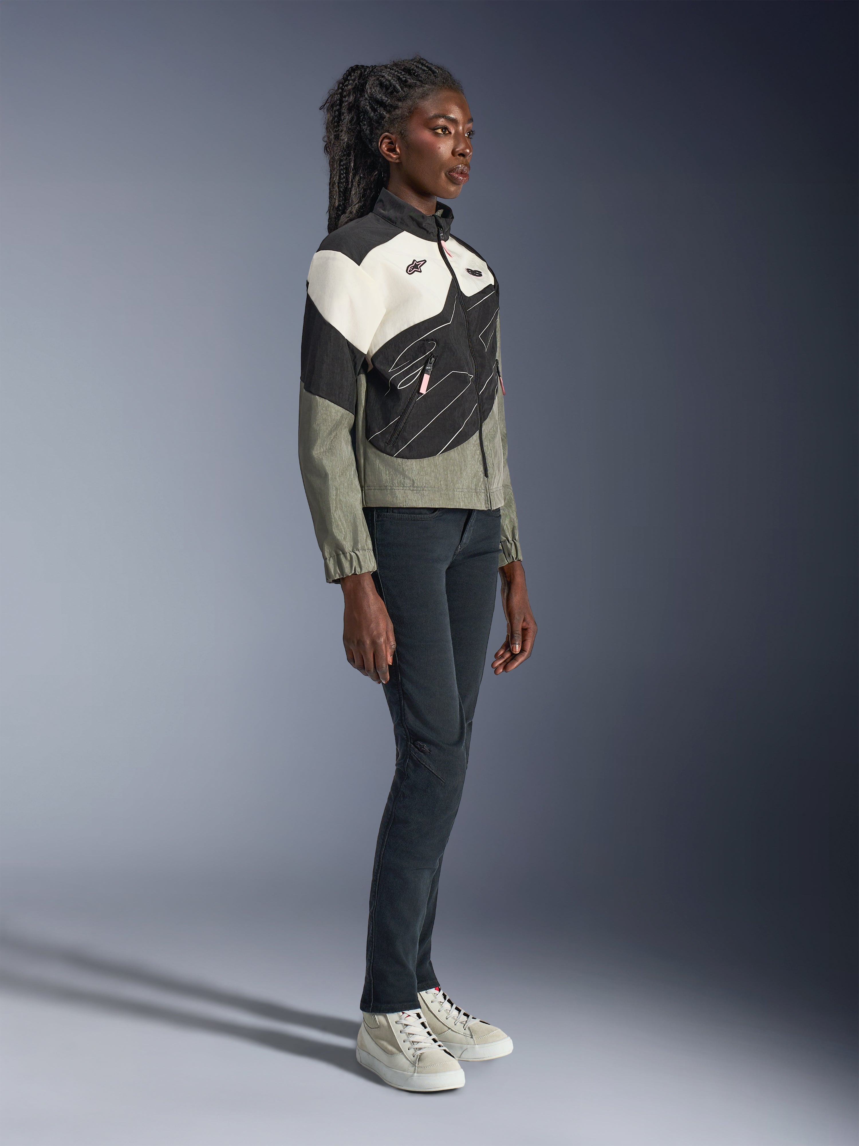 Alpinestars Stella Moshell Jacket, Women's Urban Motorcycle Jacket, Gray Black and Off-White with pink accents, full-length view of female model wearing dark pants and sneakers, contemporary streetwear-inspired design for urban riding