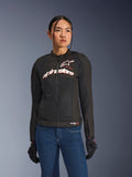 Woman wearing Alpinestars Stella SMX Air Jacket, Black White Red Fluo, textile motorcycle jacket with ventilated mesh and white chest logo, styled with blue jeans and black riding gloves, feminine fit for sport riding
