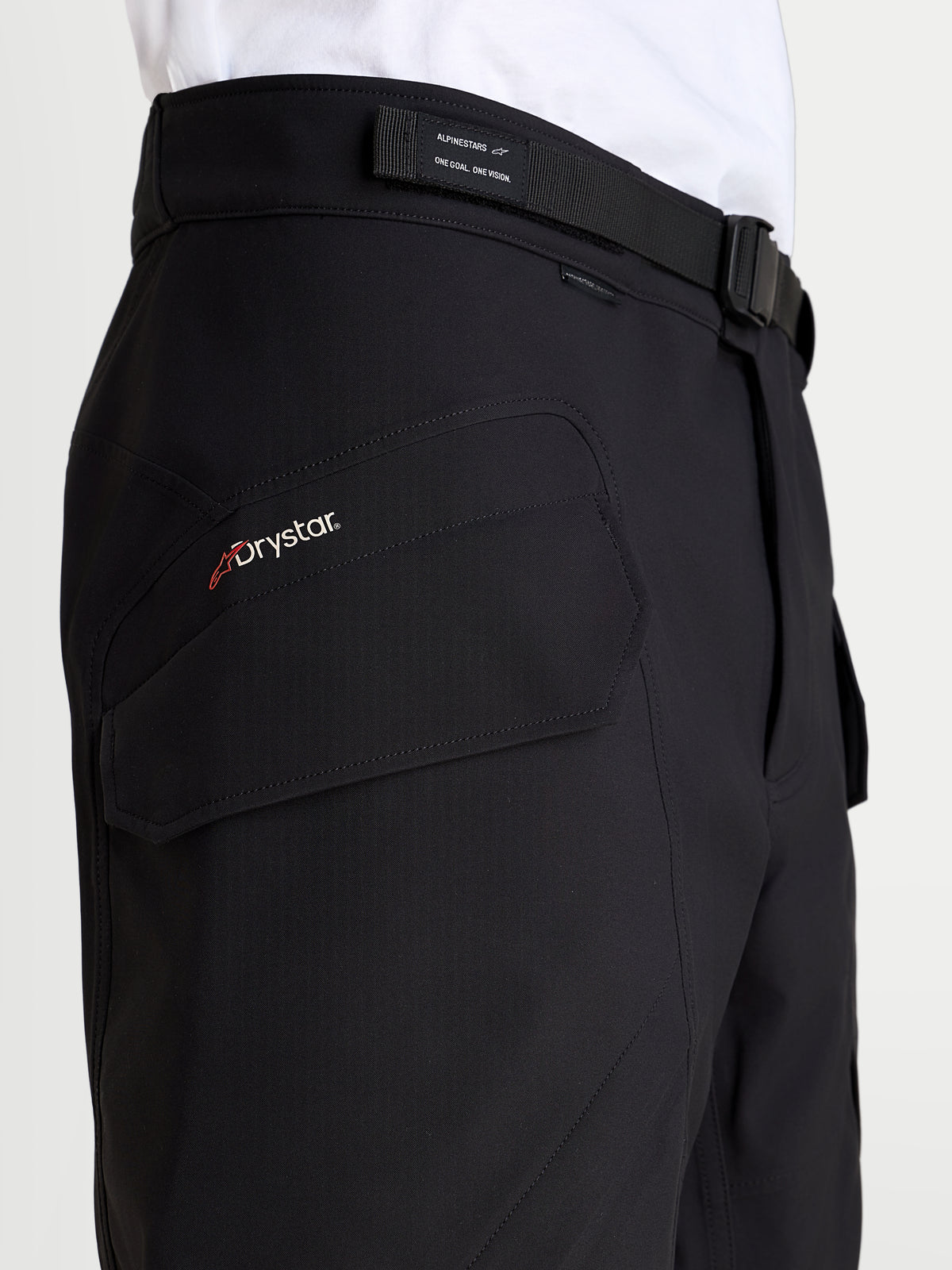 Alpinestars Juggernaut V2 Drystar® Pants, men's waterproof urban motorcycle pants in black, close-up view showing the side cargo pocket with Drystar branding and adjustable belt waist