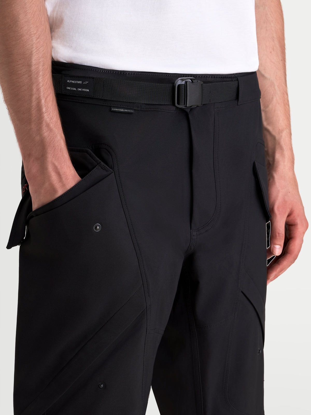 Alpinestars Juggernaut V2 Drystar® Pants, urban motorcycle pants in black, close-up view showing the adjustable belt, magnetic buckle, and front cargo pockets on a model