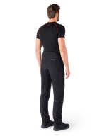 Alpinestars Alden Pants, Black, urban motorcycle pants shown from the back on a model, worn with a black short-sleeve base layer and black riding shoes, featuring quilted detailing and reflective MO.ST.EQ. branding on the back yoke.