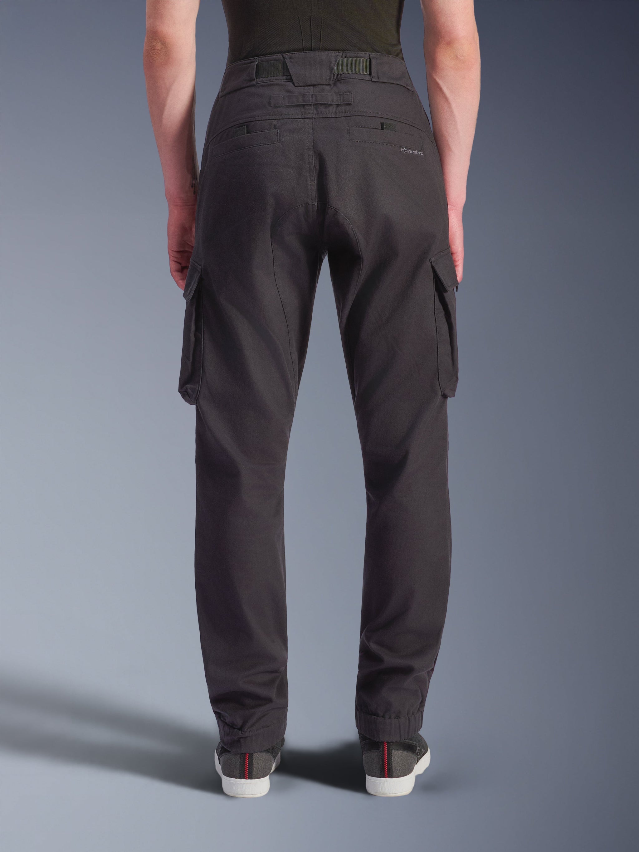 Alpinestars Flex-AST Cargo Pants, Black, rear view of technical motorcycle pants showing a regular tapered fit with elasticated hems, featuring large cargo pockets and subtle branding, designed for urban riding.