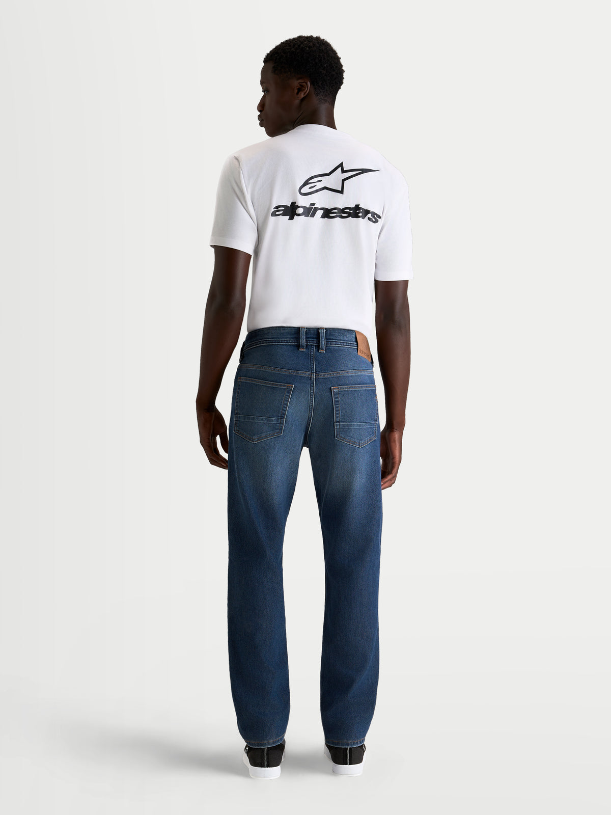 Alpinestars Flex-AST 8 Denim, calças de ganga de moto urbanas para homem em azul médio, vista traseira a mostrar a construção em ganga técnica de camada única e o estilo clássico de cinco bolsos num modelo
