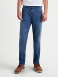 Alpinestars Flex Ast 7 Denim calças de moto urbanas para homem, azul claro, vista frontal num modelo com roupa casual e botas castanhas, calças de ganga técnicas com certificação AA