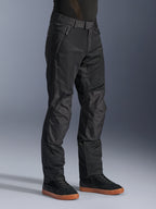 Calças Alpinestars C-1 Air, calças de motociclismo urbanas, pretas, com painéis de malha técnica respirável e construção em polifibra, usadas com sapatilhas pretas, design limpo e funcional para condução urbana.