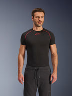 Calças Alpinestars Aeroshell Airflow, calças de motociclismo pretas, em tecido softshell leve, com cintura ajustável por cordão e ventilação perfurada a laser, usadas com uma camisola de base preta da Alpinestars
