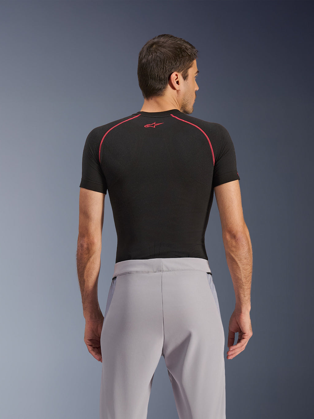 Alpinestars Aeroshell Airflow Pants, Mid Gray, back view, worn with a black short-sleeve base layer with red stitching and logo, featuring lightweight stretch softshell textile and mesh paneling for maximum ventilation, ergonomic sport fit for motorcycle riding