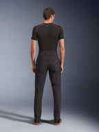 Alpinestars Flex-AST Canvas Pants, calças de motociclismo urbanas, pretas, vista traseira que mostra o design inspirado em roupa de trabalho com bolsos traseiros e subida traseira prolongada, usadas com uma camada de base preta e sapatilhas, corte ergonómico para condução