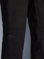 Alpinestars Flex-AST Canvas Pants, calças de motociclismo urbanas, pretas, grande plano da zona do joelho com painéis pré-moldados e um logótipo bordado discreto em tecido de lona resistente