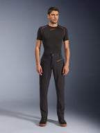 Alpinestars Flex-AST Canvas Pants, calças de motociclismo urbanas, pretas, usadas por um modelo com uma camisola interior de manga curta preta com costuras vermelhas e sapatilhas casuais pretas, destacando os bolsos frontais com fecho de correr e o design ergonómico em lona