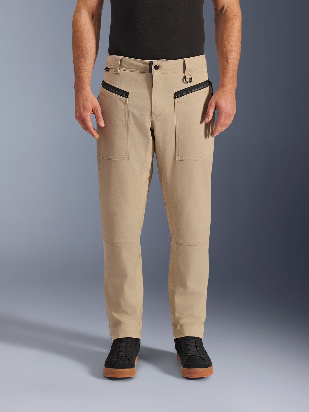 Alpinestars Flex-AST Canvas Pants, calças de motociclismo urbanas, castanhas, estilo workwear clássico, com bolsos frontais com fecho horizontal pretos e argola em D no passador do cinto, usadas com camisa e sapatos pretos, vista frontal em estúdio
