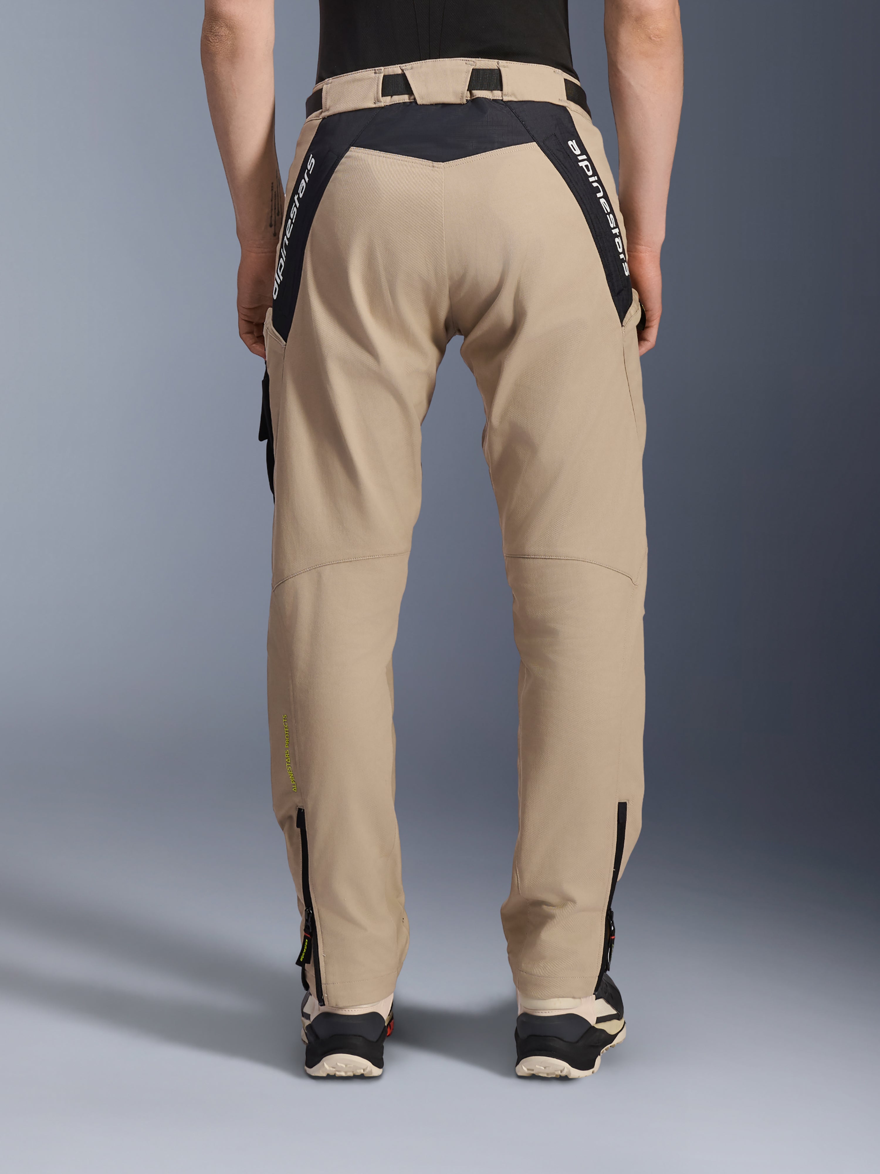 Alpinestars Acteon Pants, Urban Motorcycle Pants, Sand, rear view featuring black ripstop panels with white branding on the yoke, tapered fit with lower leg zippers, contemporary road riding gear