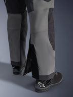 Alpinestars Maxdura Dual Pants, Adventure Motorcycle Pants, Dark Gray and Deep Gray, close-up view of adjustable over-the-boot leg hem with snap closures and reinforced panels, worn with black Alpinestars boots, rugged technical design for dual-sport riding