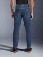 Alpinestars Flex-AST 5 Denim Pants, calças de ganga para motociclismo urbano, azul índigo lavado, vista traseira mostrando o corte afunilado e bolsos traseiros com patch da marca, estilo casual