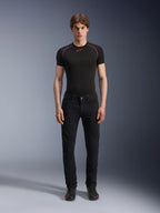 Alpinestars Copper V3 Denim Pants em Black Rinse, calças de ganga com corte de perna reta e conforto regular, modelo masculino com t-shirt de camada de base preta e costuras vermelhas contrastantes, ténis de condução pretos, conjunto de vestuário urbano para motociclismo