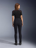 Alpinestars Stella Flex-Ast Leggings, leggings de motociclismo para mulher, pretas, vista traseira exibindo o corte justo de cintura alta, usadas com top preto de manga curta e botas de condução pretas, equipamento de condução urbana