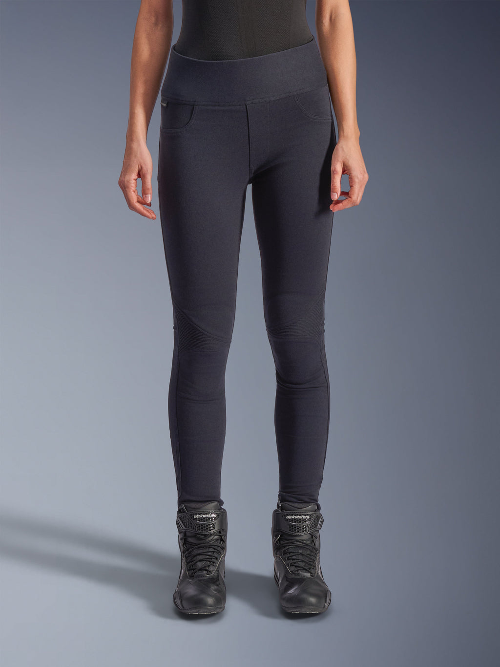 Alpinestars Stella Flex-Ast Leggings, leggings de motociclismo para mulher, pretas, corte de cintura alta com painéis articulados nos joelhos e costuras contornadas, usadas por modelo com botas de condução pretas, vestuário de condução de performance urbana