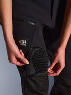 Calças Alpinestars Stella Flex-AST Explorer em preto, pormenor do bolso externo para proteções com a inserção da proteção de joelho Nucleon Flex Plus, detalhe da proteção com padrão em favo de mel, logótipo "ALL TERRA" na coxa, equipamento têxtil funcional de aventura para mulher
