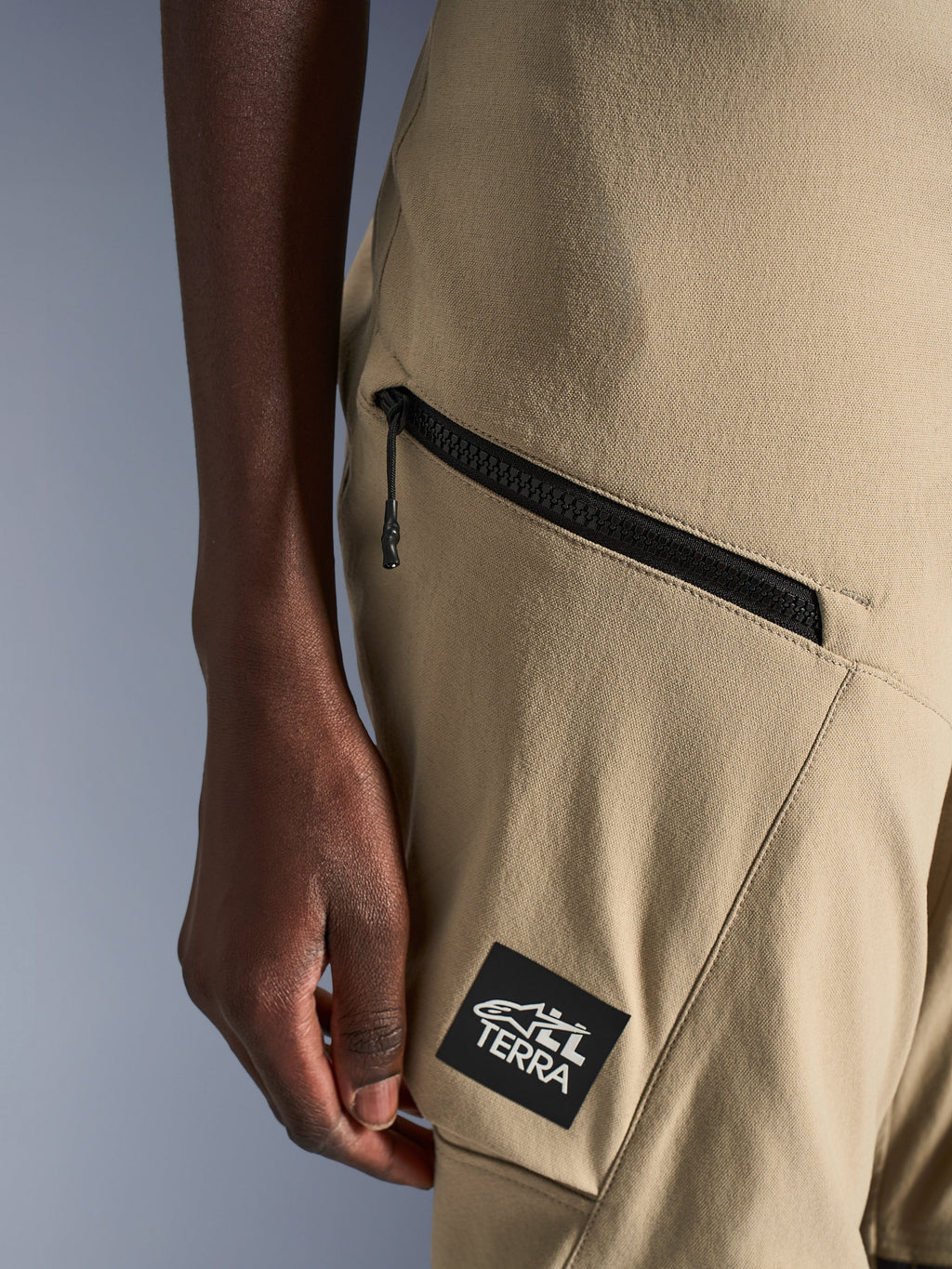 Alpinestars Stella Flex-AST Explorer Pants, calças de motociclista para mulher, cor areia, pormenor de bolso cargo com fecho de correr e patch preto com logótipo ALL TERRA, construção têxtil ripstop durável para condução de aventura