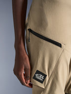 Alpinestars Stella Flex-AST Explorer Pants, calças de motociclista para mulher, cor areia, pormenor de bolso cargo com fecho de correr e patch preto com logótipo ALL TERRA, construção têxtil ripstop durável para condução de aventura