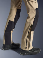 Calças Alpinestars Stella Flex-AST Explorer, calças de motociclismo para mulher, areia e preto, pormenor da parte inferior das pernas mostrando uma bainha com fecho de correr para ajuste às botas, usadas com sapatos de condução Alpinestars pretos, com painéis de tecido ripstop durável e elástico respirável