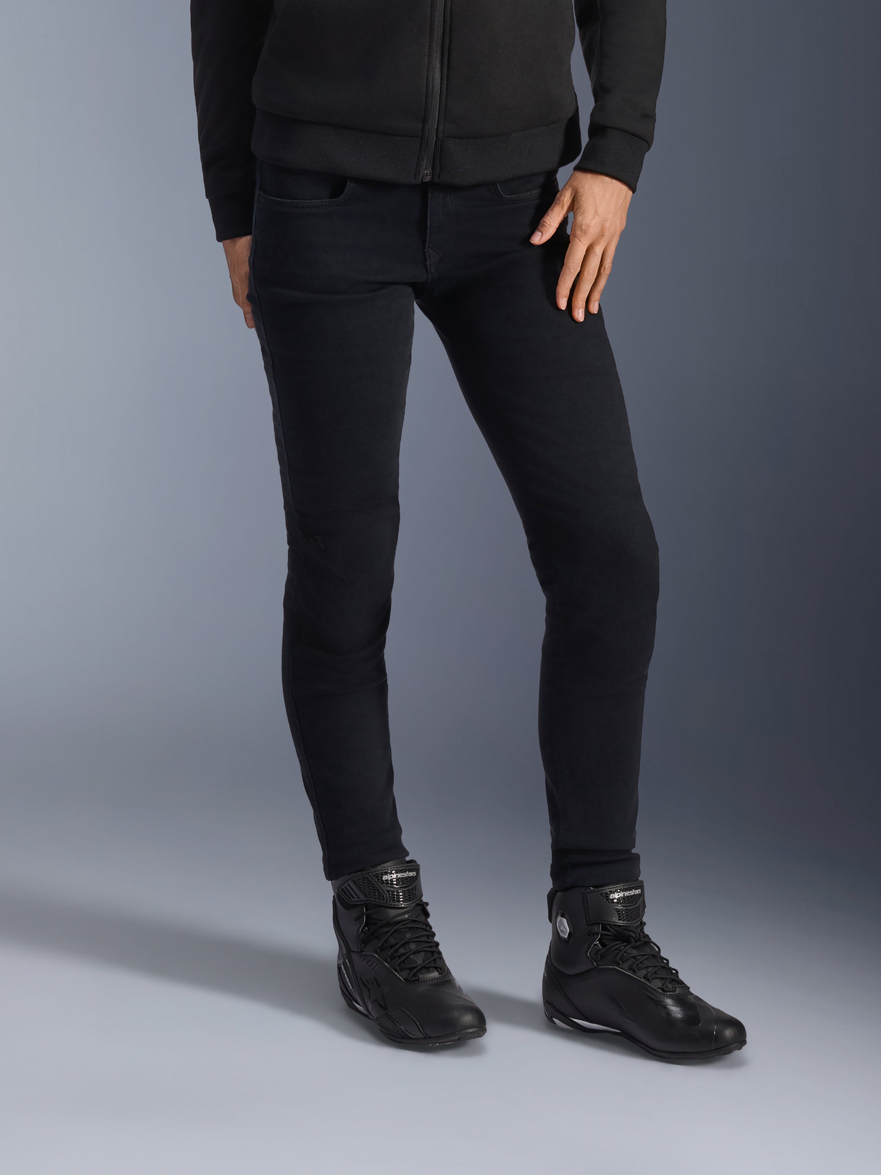 Alpinestars Daisy V3, calças de ganga de motociclismo para mulher, pretas (Rinse Black), corte slim-fit, combinadas com botas de motociclismo de cano alto pretas e casaco com capuz e fecho, estilo urbano monocromático elegante