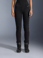 Alpinestars Womens Banshee Leggings, calças de motociclismo pretas, design justo com painéis em acordeão nos joelhos, usadas com botas de condução pretas de cano alto, equipamento urbano de estrada com estilo casual