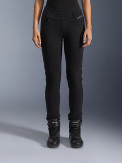 Alpinestars Womens Banshee Leggings, calças de motociclismo pretas, design justo com painéis em acordeão nos joelhos, usadas com botas de condução pretas de cano alto, equipamento urbano de estrada com estilo casual