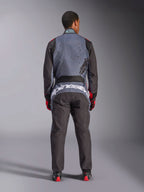Alpinestars KMX-9 V3 Graphic 6 Suit, fato de karting, preto antracite e vermelho, vista traseira mostrando o logótipo Alpinestars em grande branco na zona lombar, parte superior cinzenta com grafismos de salpicos pretos, braços e pernas pretos, usado com luvas e botas de competição vermelhas e pretas.
