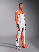 Alpinestars KMX-9 V3 Graphic 6 Karting Suit, White Orange and Black, featuring a speckled pattern and vibrant orange sleeves, worn by a model with matching racing gloves and shoes, professional dual-layer motorsport gear.
