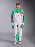 Fato Alpinestars KMX-9 V3 Graphic 6, branco, verde e vermelho, fato de karting de uma peça com um padrão gráfico de salpicos pretos, painéis verdes nas mangas e pernas, logótipo Alpinestars vermelho no peito, usado com luvas e sapatos de corrida a condizer