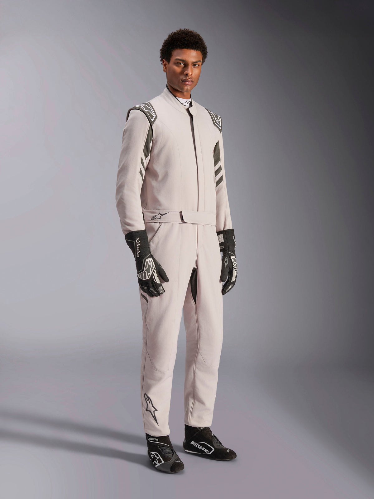 Alpinestars GP Race V3 Suit FIA, fato de corrida Silver Anthracite, fato de piloto de uma só peça com dragonas nos ombros e cintura com cinto, usado com luvas e botas de corrida pretas e brancas a condizer, design elegante para automobilismo profissional