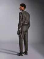 Alpinestars GP Race V3 Suit FIA, fato de automobilismo preto com detalhes prateados, usado por um modelo numa vista traseira de três quartos, combinado com luvas e botas de corrida pretas a condizer, equipamento profissional de desporto motorizado com um design elegante de duas camadas.