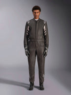 Macacão Alpinestars GP Race V3 FIA, fato de automobilismo, preto e prateado, vista frontal de um piloto a usar equipamento de corrida completo, incluindo luvas e botas, design profissional de desporto motorizado com a marca Alpinestars nos ombros e no cinto