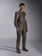 Piloto masculino a usar o fato Alpinestars GP Race V3 FIA, fato de automobilismo em preto e prateado, completo com luvas e sapatos a condizer, com detalhes prateados nos ombros e na parte inferior da perna, equipamento de automobilismo profissional com um ajuste à medida