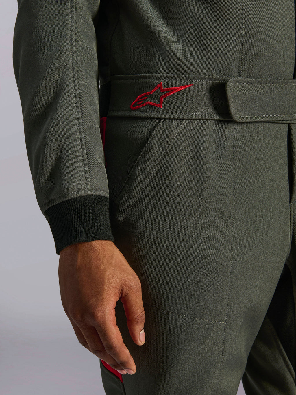 Alpinestars GP Race V3 Suit FIA, fato de automobilismo, antracite e vermelho, grande plano do cinto ajustável na cintura com um logótipo vermelho bordado e punho da manga canelado preto em tecido de sarja texturizada