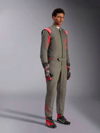 Fato Alpinestars GP Race V3 FIA, fato de automobilismo Antracite Vermelho, usado com luvas e botas de competição a condizer, com ombreiras vermelhas e logótipos da marca, design técnico elegante de duas camadas para desportos motorizados