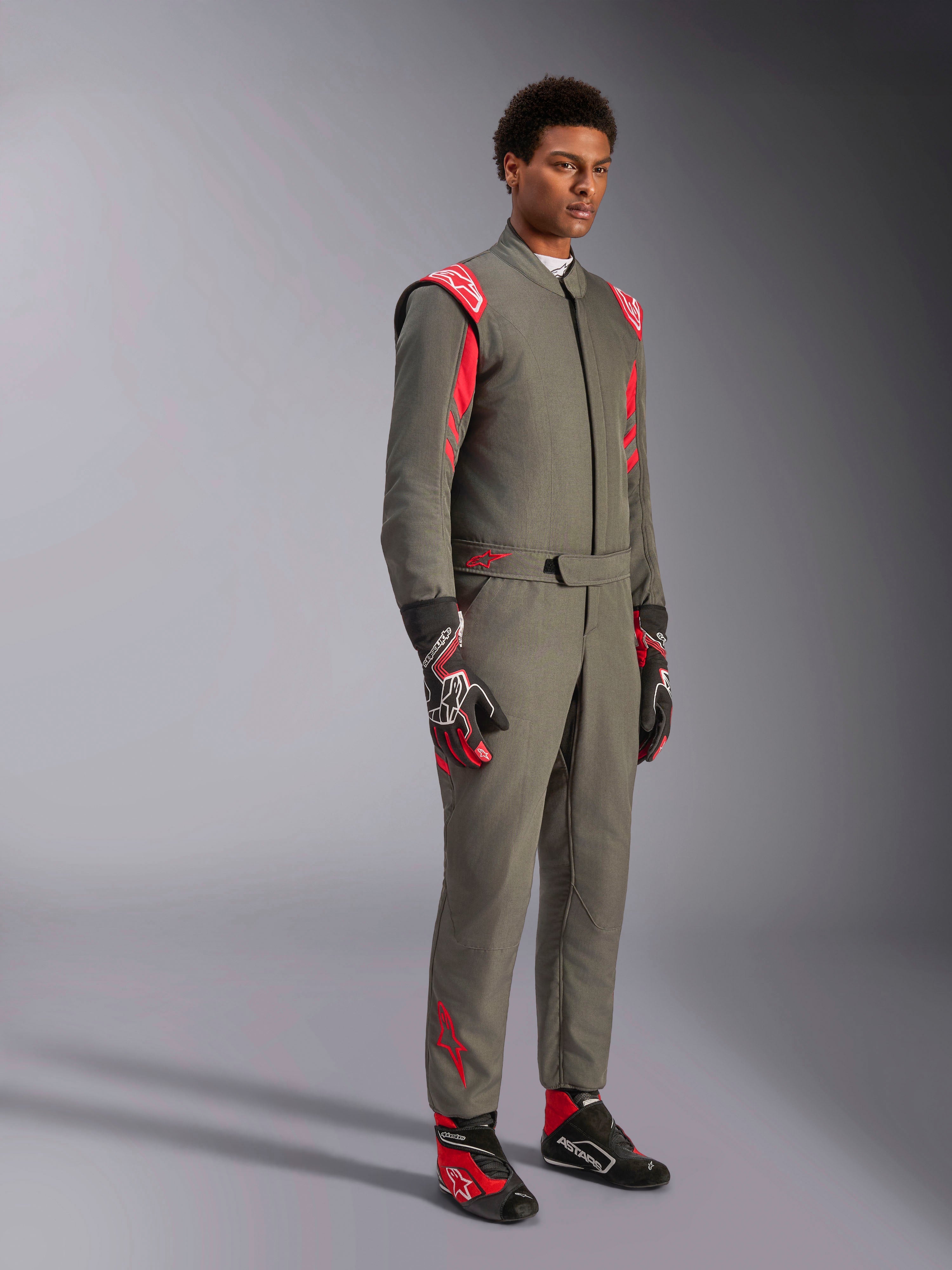 Fato Alpinestars GP Race V3 FIA, fato de automobilismo Antracite Vermelho, usado com luvas e botas de competição a condizer, com ombreiras vermelhas e logótipos da marca, design técnico elegante de duas camadas para desportos motorizados