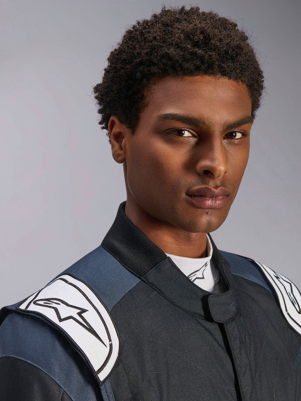 Alpinestars GP Pro Comp V2 - FIA, macacão de automobilismo masculino, preto e asfalto com dragonas brancas com logótipo.