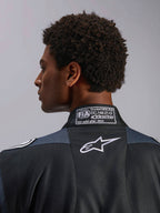 Alpinestars GP Pro Comp V2 FIA, macacão de corrida auto para homem, preto e asfalto, certificação FIA 8856-2018 e logótipo Astar branco, pormenor do colarinho.