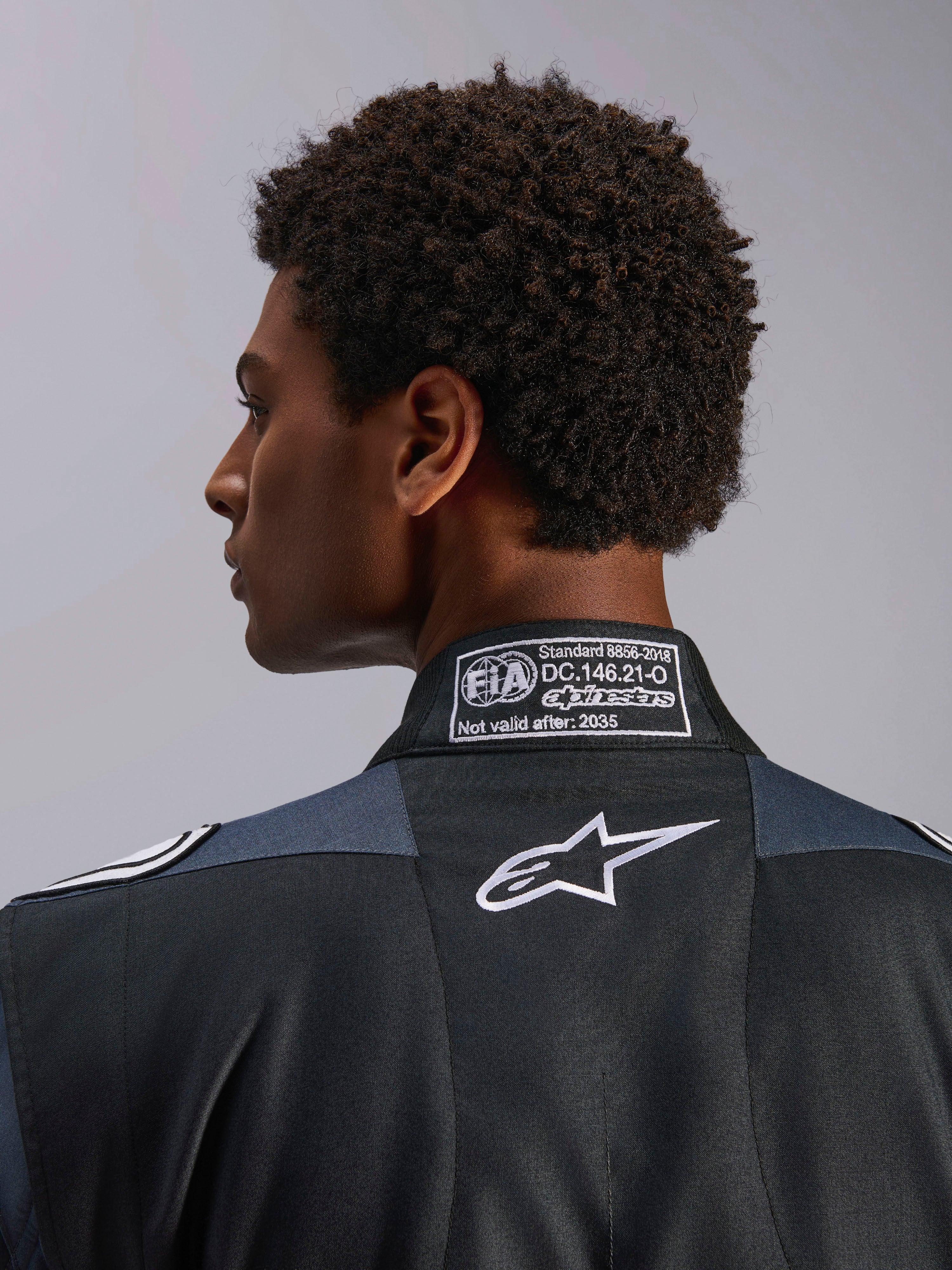 Alpinestars GP Pro Comp V2 FIA, macacão de corrida auto para homem, preto e asfalto, certificação FIA 8856-2018 e logótipo Astar branco, pormenor do colarinho.