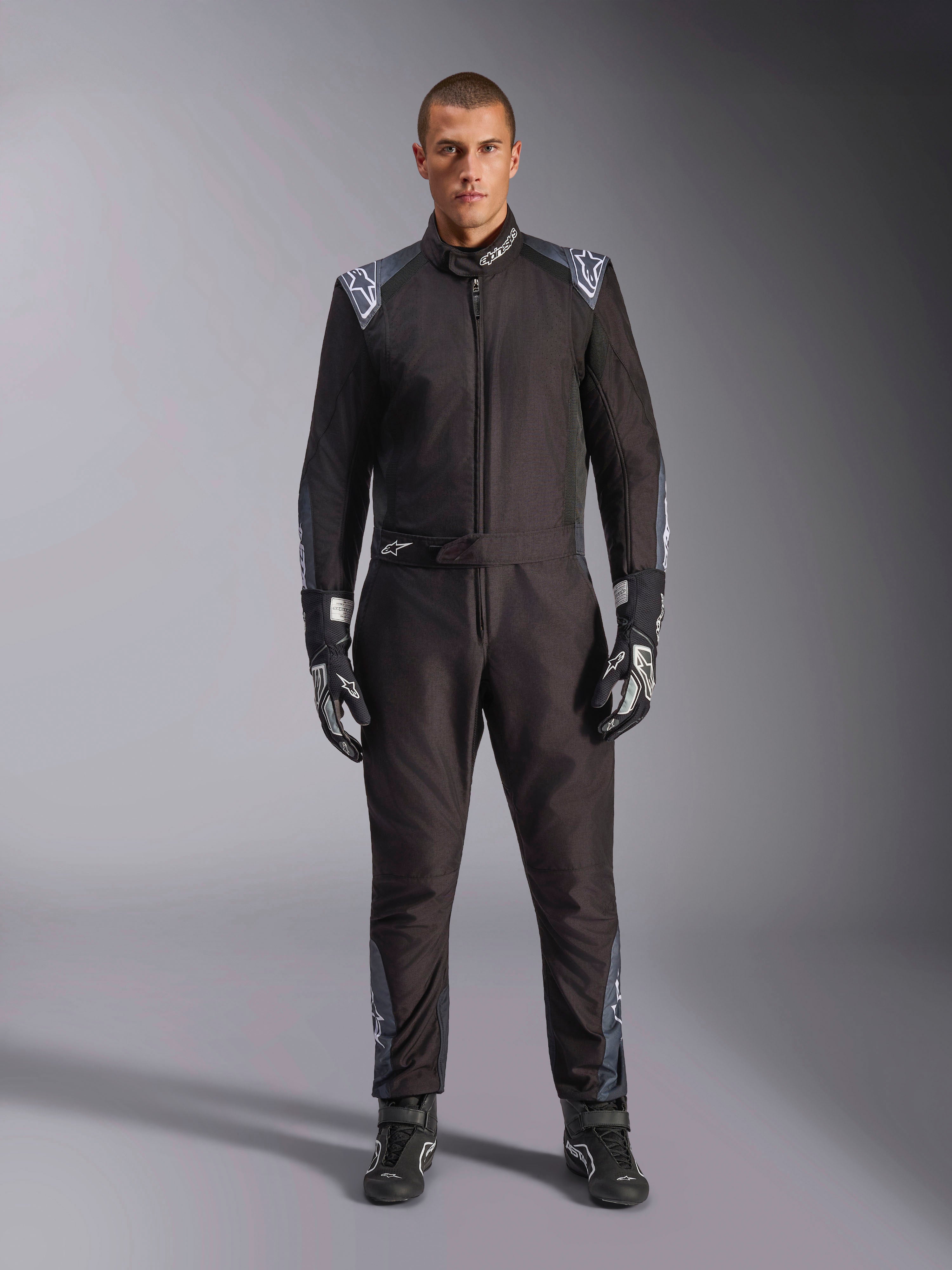Alpinestars KMX-5 V3 Suit, macacão de karting, preto Dark Shadow, vista de corpo inteiro de um modelo com luvas e botas a combinar, detalhes em cinzento escuro e logótipos Alpinestars brancos nos ombros e cinto, equipamento profissional de desporto motorizado