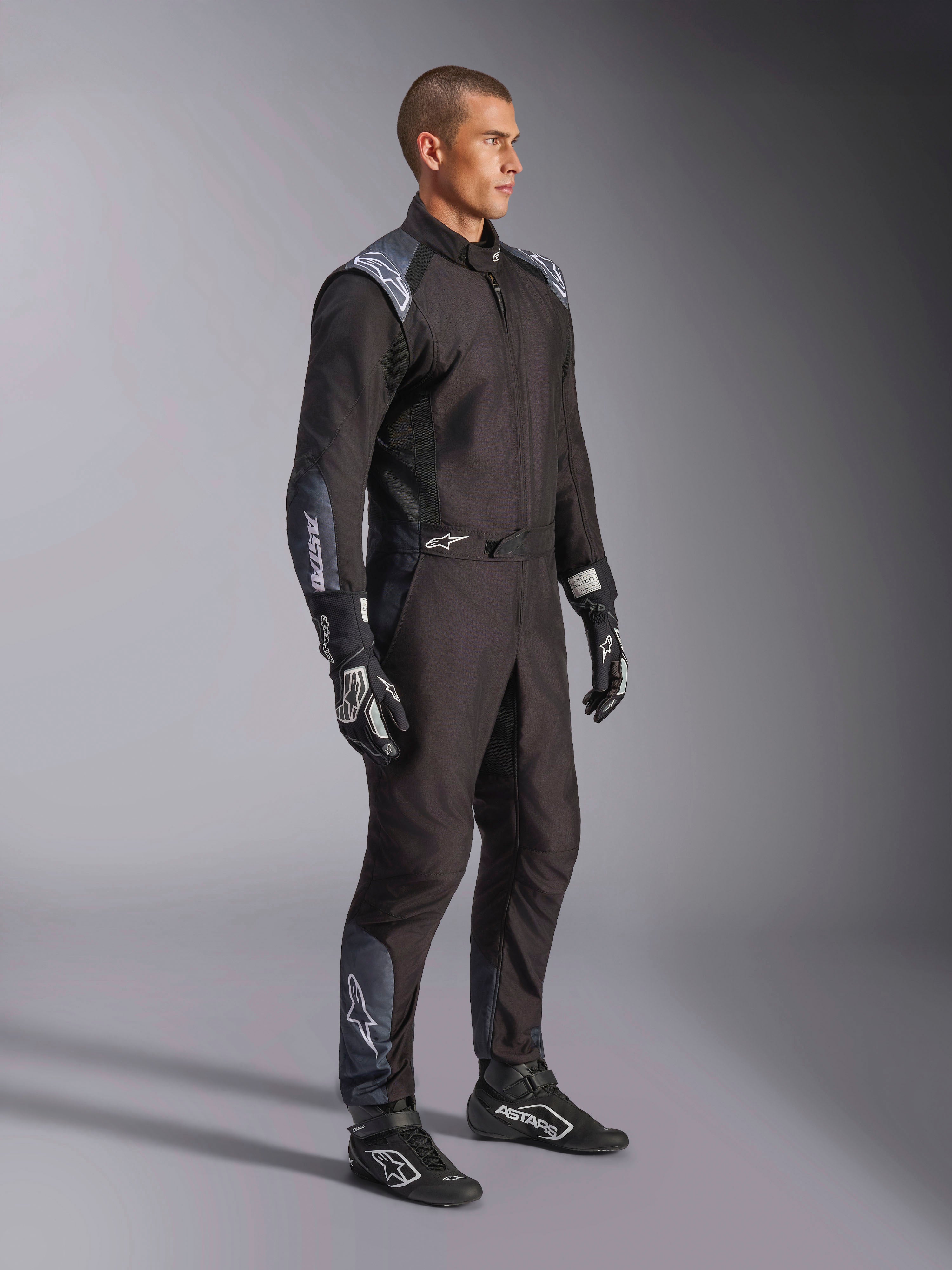 Macacão Alpinestars KMX-5 V3, fato de karting em Black Dark Shadow, usado com luvas e botas de corrida pretas a condizer, com perfurações cortadas a laser e painéis de malha tecnológica, design elegante de camada dupla com logótipos brancos para desporto motorizado profissional