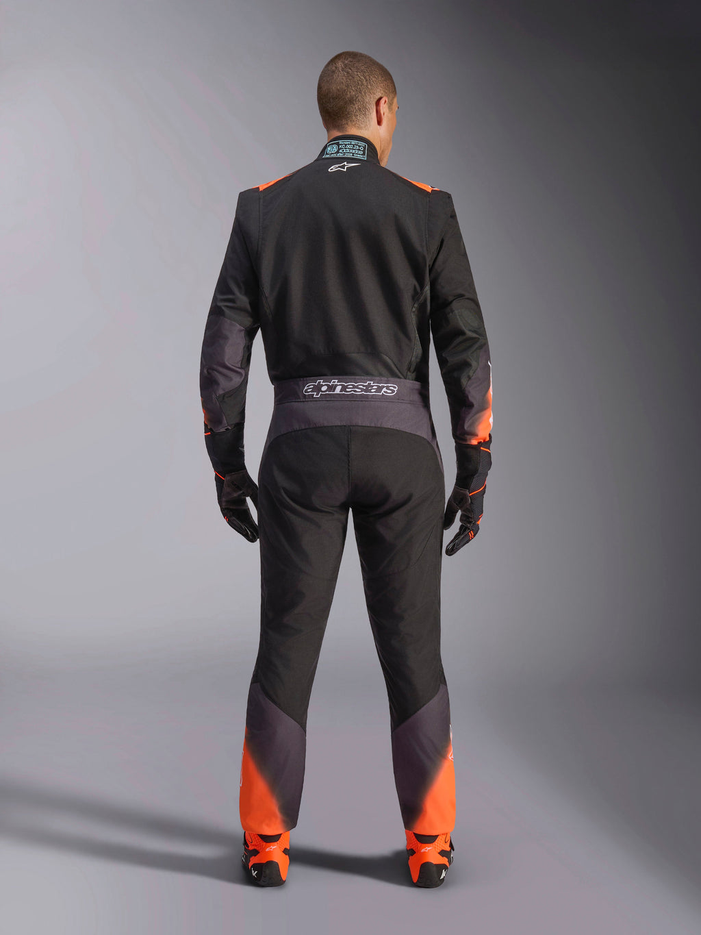 Alpinestars Macacão KMX-5 V3, macacão de karting para homem, preto e laranja fluo, vista traseira, certificado FIA.