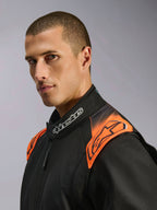 Alpinestars KMX-5 V3, macacão de karting preto e laranja fluo, certificado FIA, pormenor da gola e ombros num modelo.