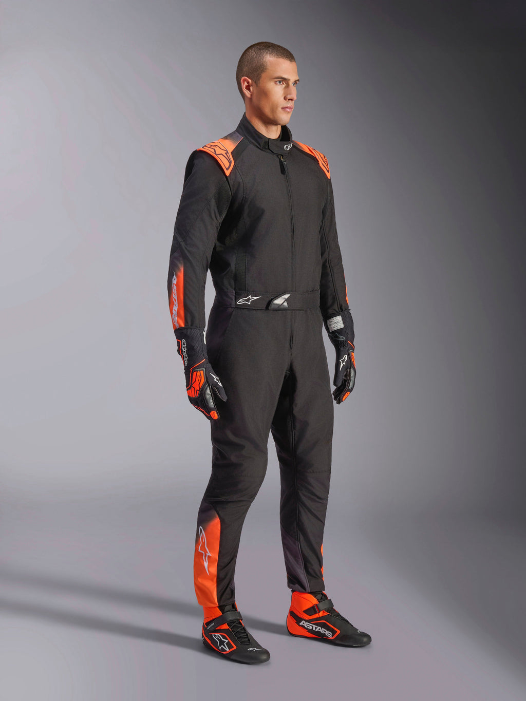 Alpinestars KMX-5 V3, macacão de karting para homem, preto e laranja fluo, certificado FIA Grau 1, visto num modelo.