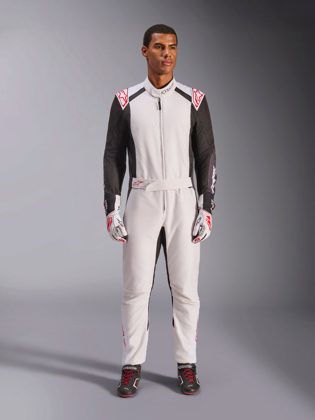 Macacão Alpinestars KMX-5 V3, macacão de karting de peça única, branco, preto e vermelho vivo, vestido por um modelo com luvas e sapatos de competição a condizer, equipamento profissional de desporto motorizado para karting de competição